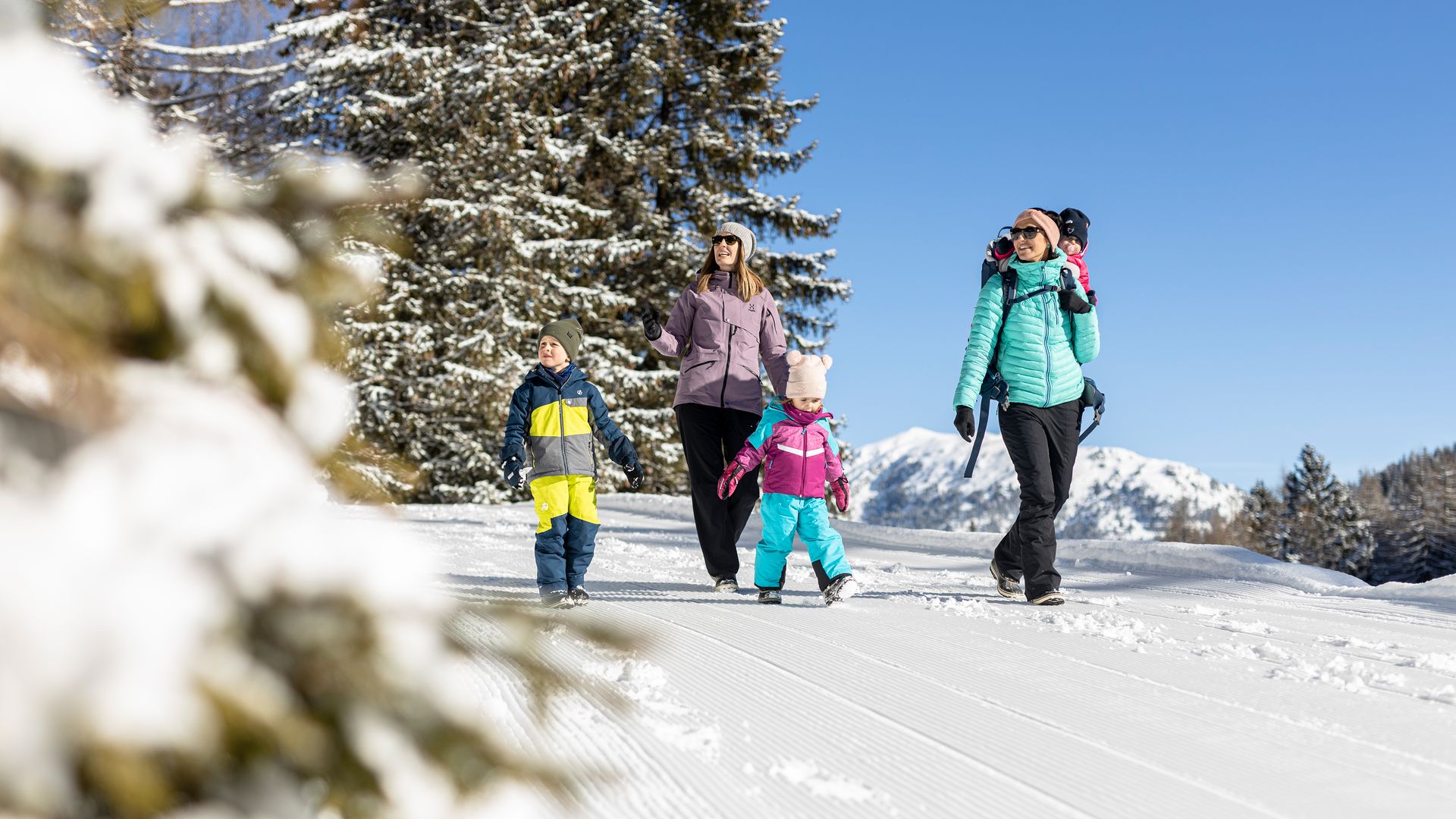 Farm Resort Geislerhof Familie macht Winterwanderung im Schnee bei klarem Himmel